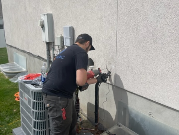 Technician repairing outdoor HVAC unit.