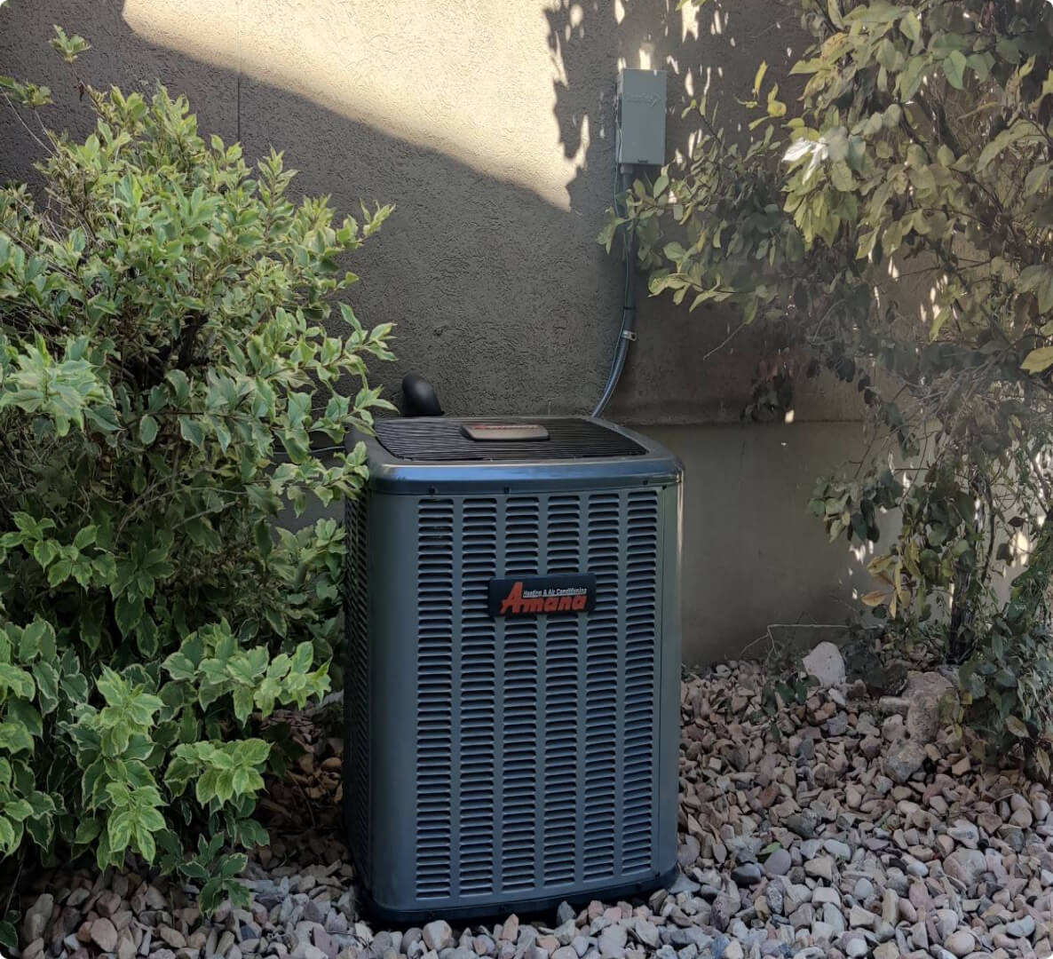 Amana air conditioning unit outside a house.