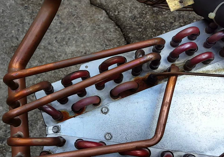 Copper pipes and red valves on mechanical equipment.